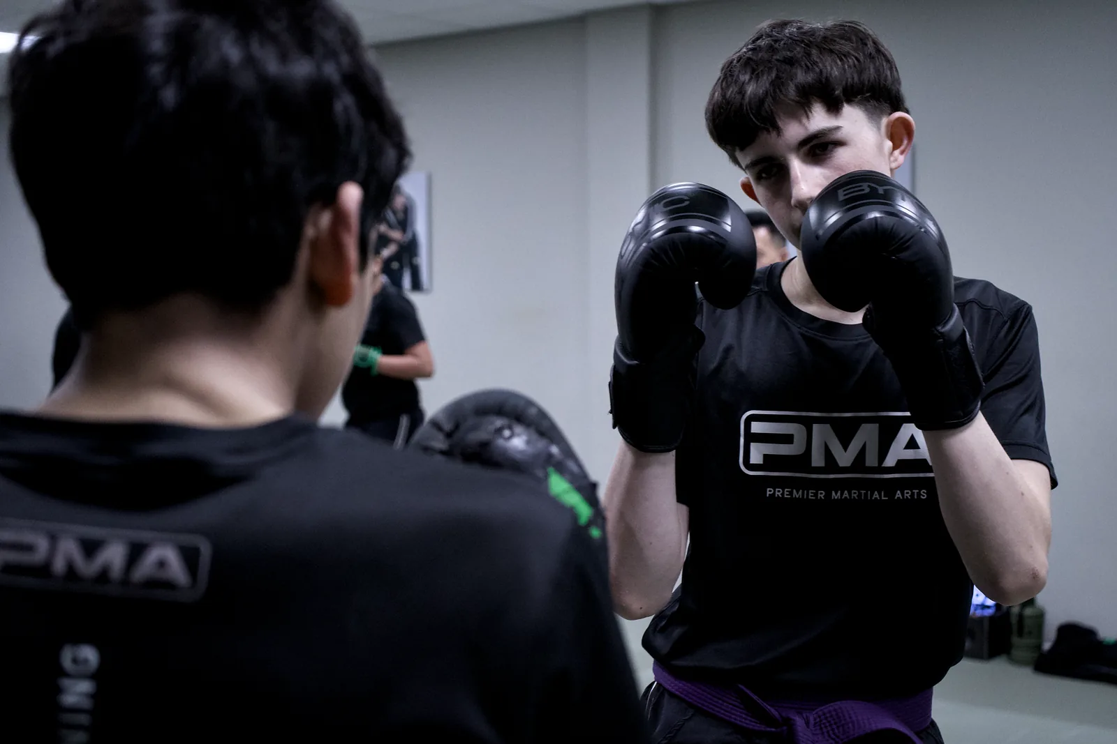 Two adults in gloves working a partner drill